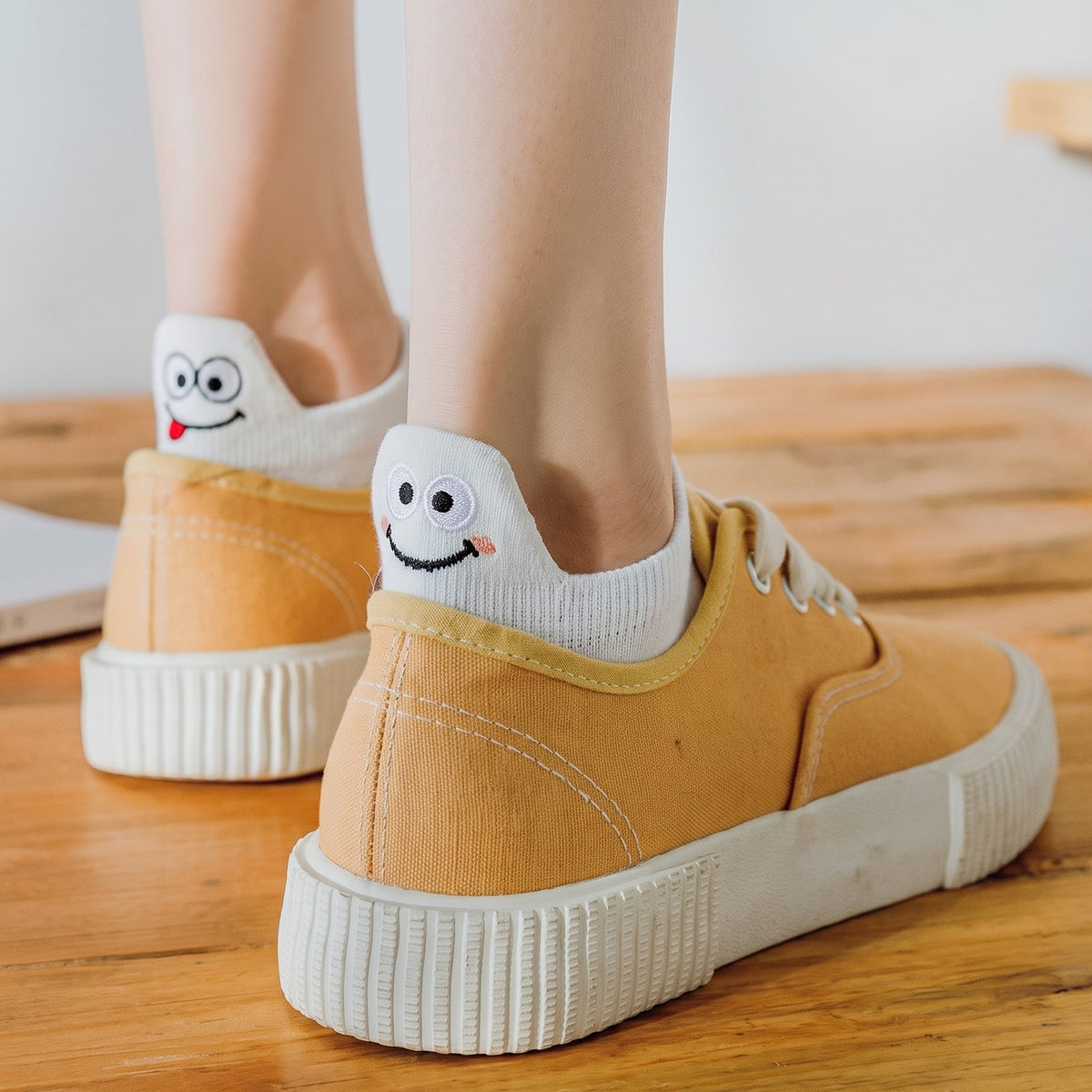 White TASSA socks peeking out of mustard canvas sneakers