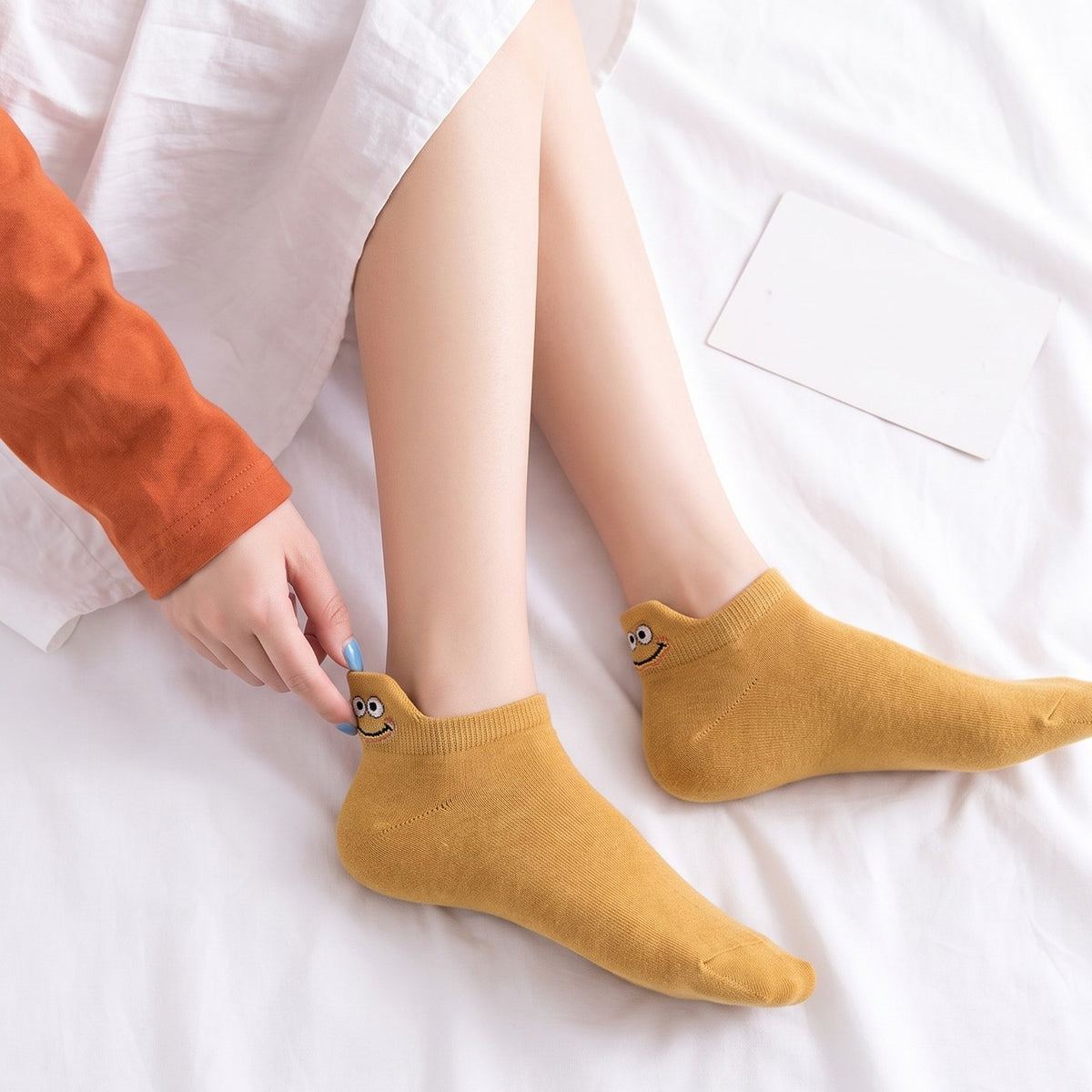 Mustard TASSA socks on a bright white bed