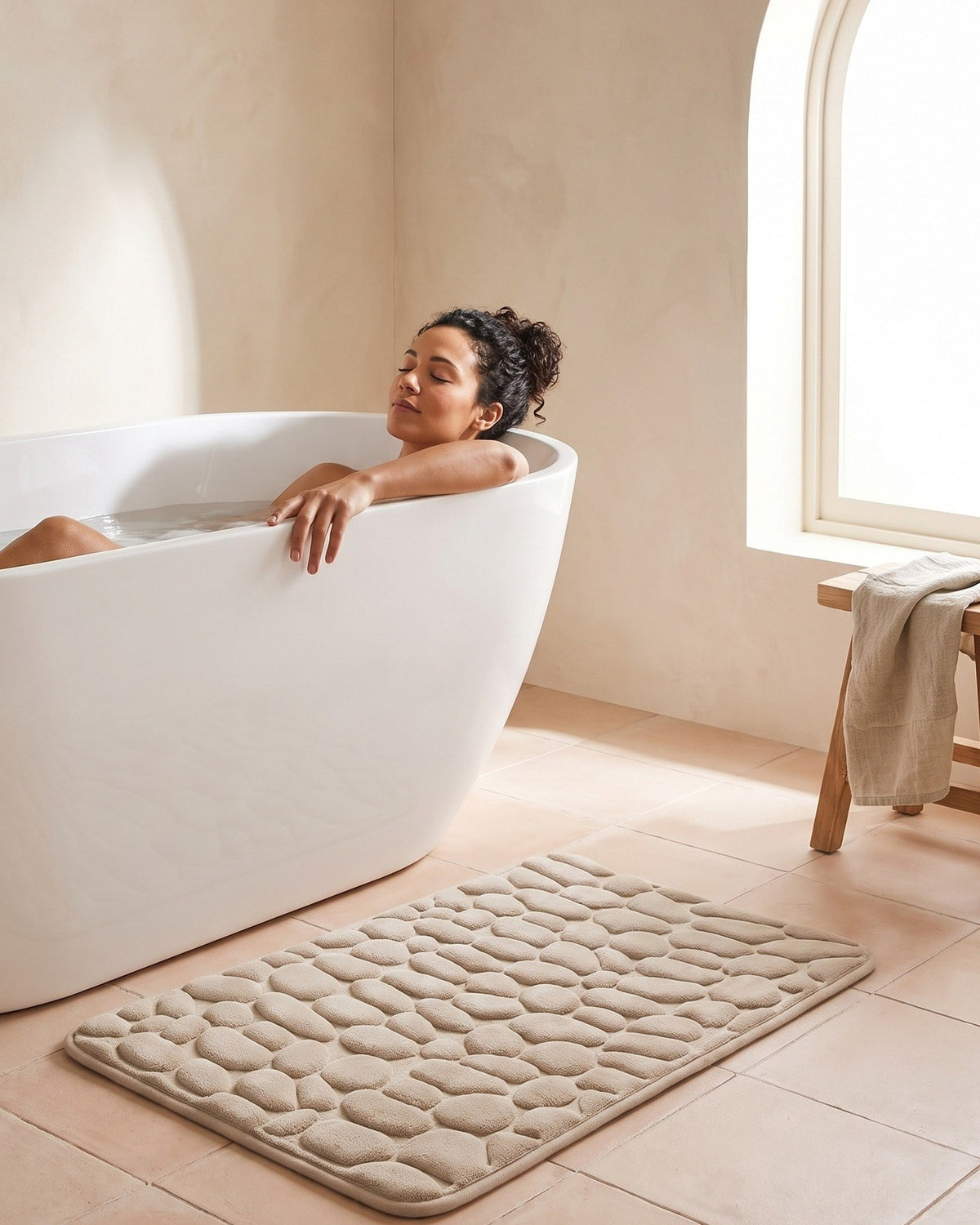 Relaxing in the bath with the Pebble Bath Mat waiting on the floor