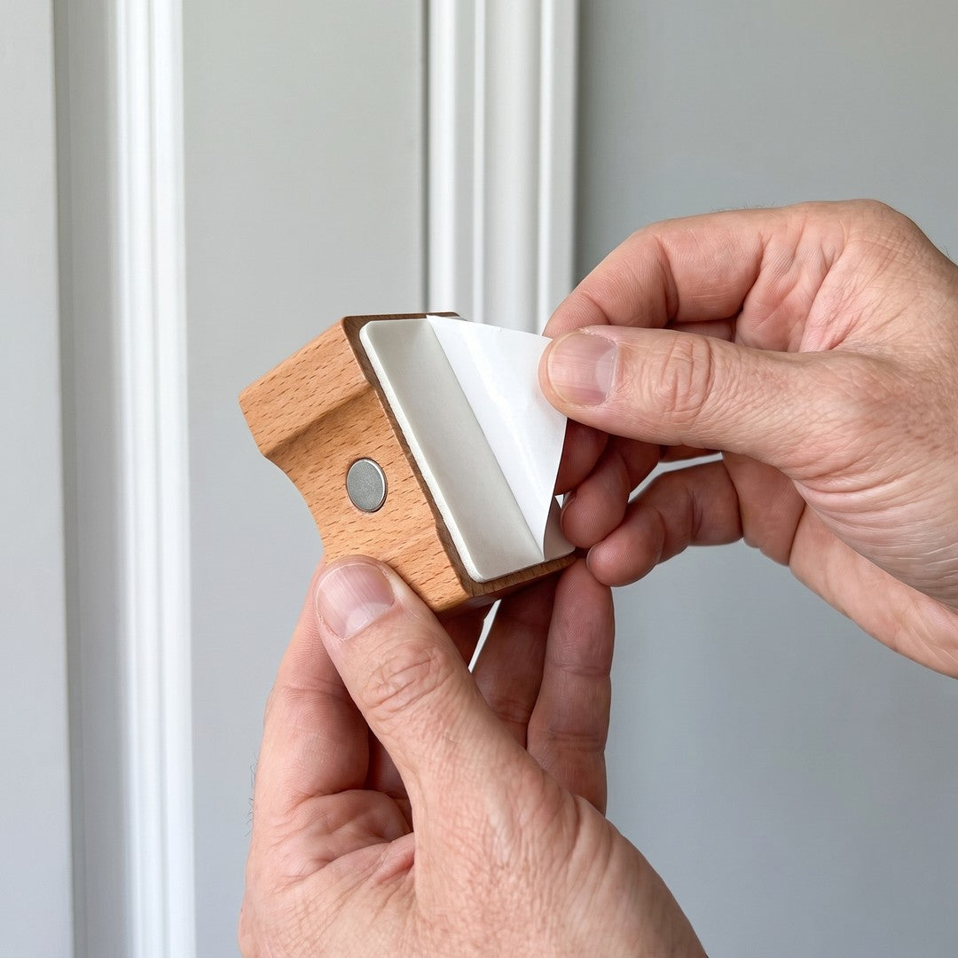 Peeling the adhesive pad on the back of the wall mount, no drilling