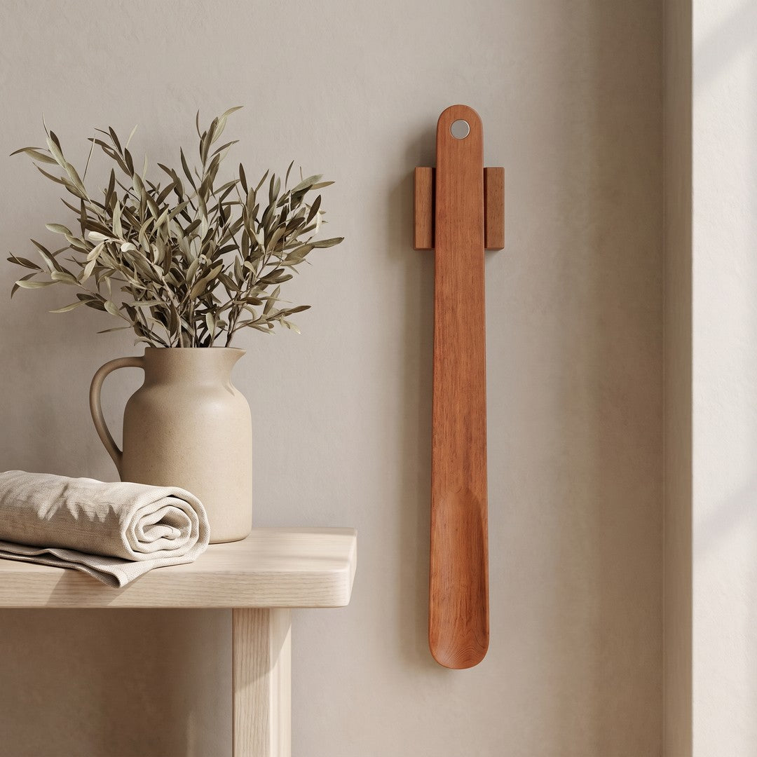 KLIVA magnetic shoehorn hanging on a plaster wall beside a small side table