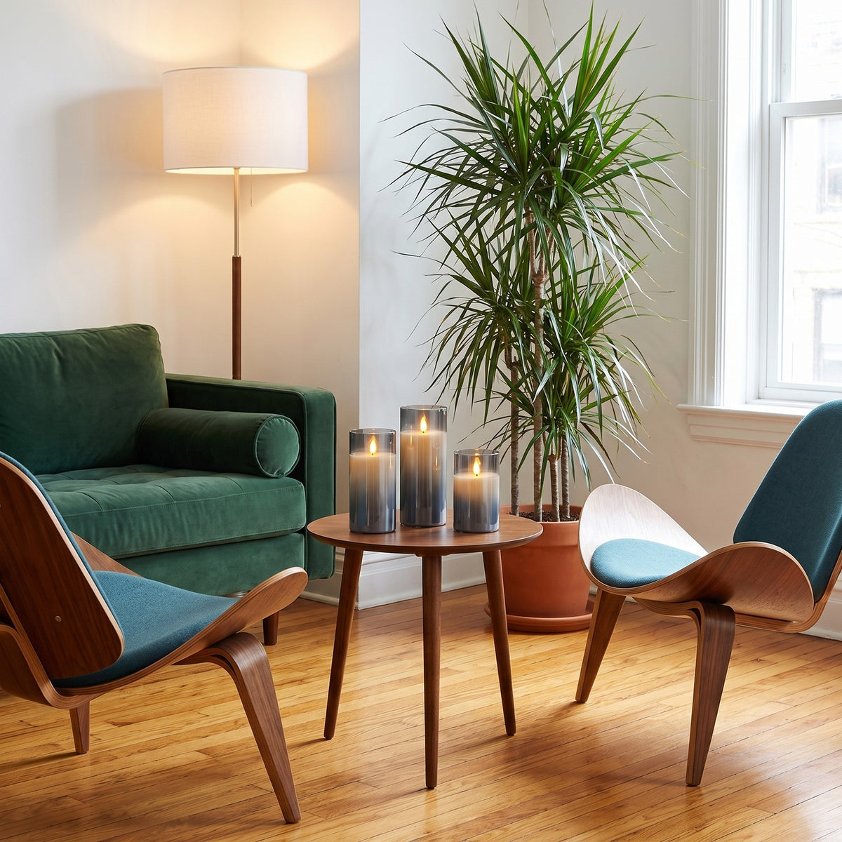 Three VEKE candles on a round walnut side table in a bright living room