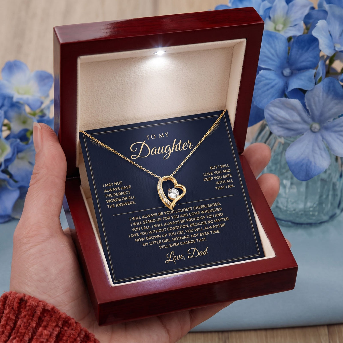 Holding the luxury mahogany box with the yellow gold necklace