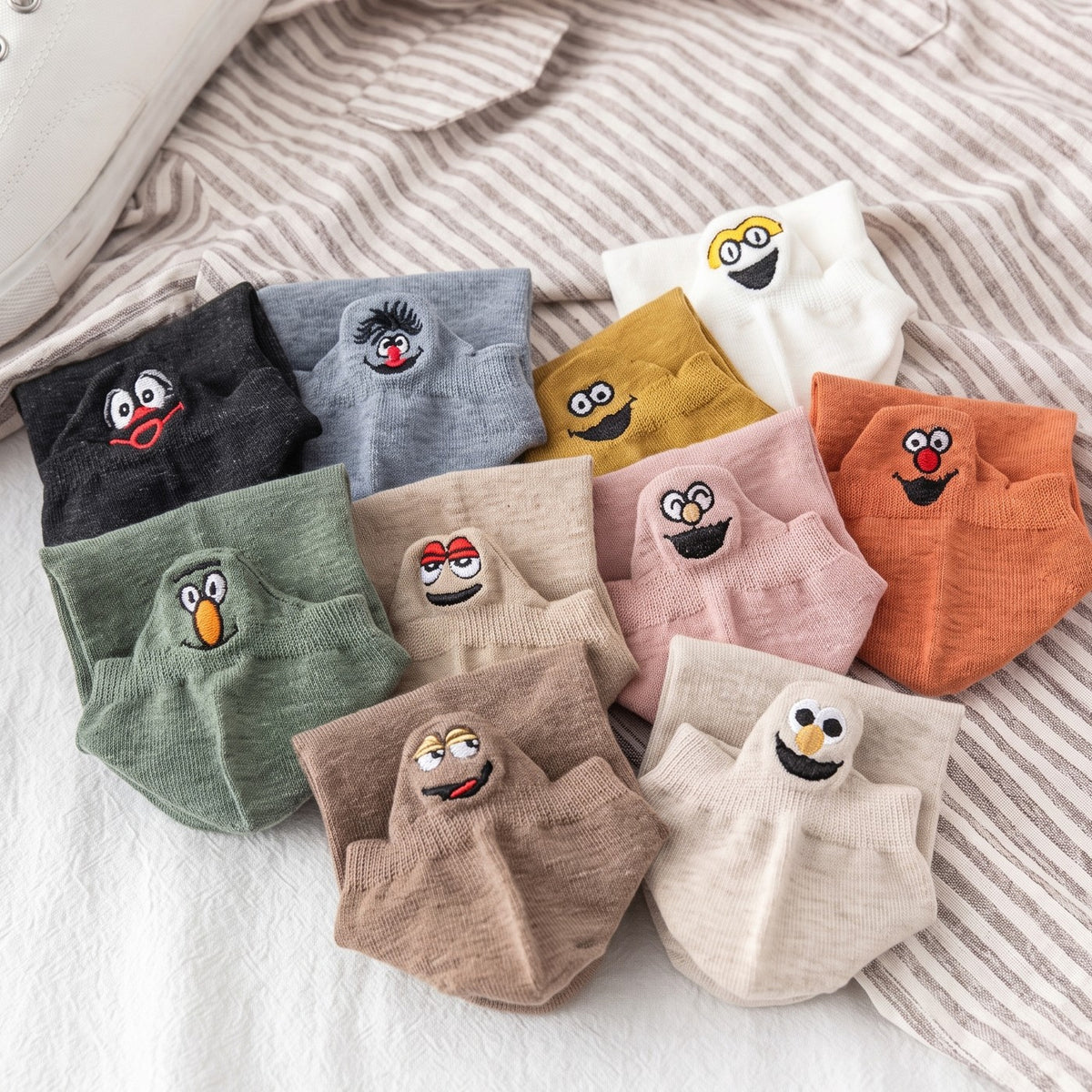 Ten pairs of TASSA socks in ten colours with smiling faces on the heel tabs