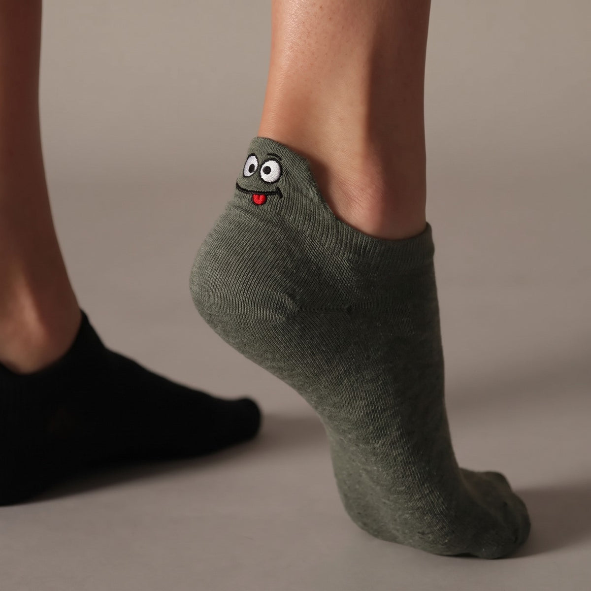 Olive TASSA sock with its heel tab standing above the heel