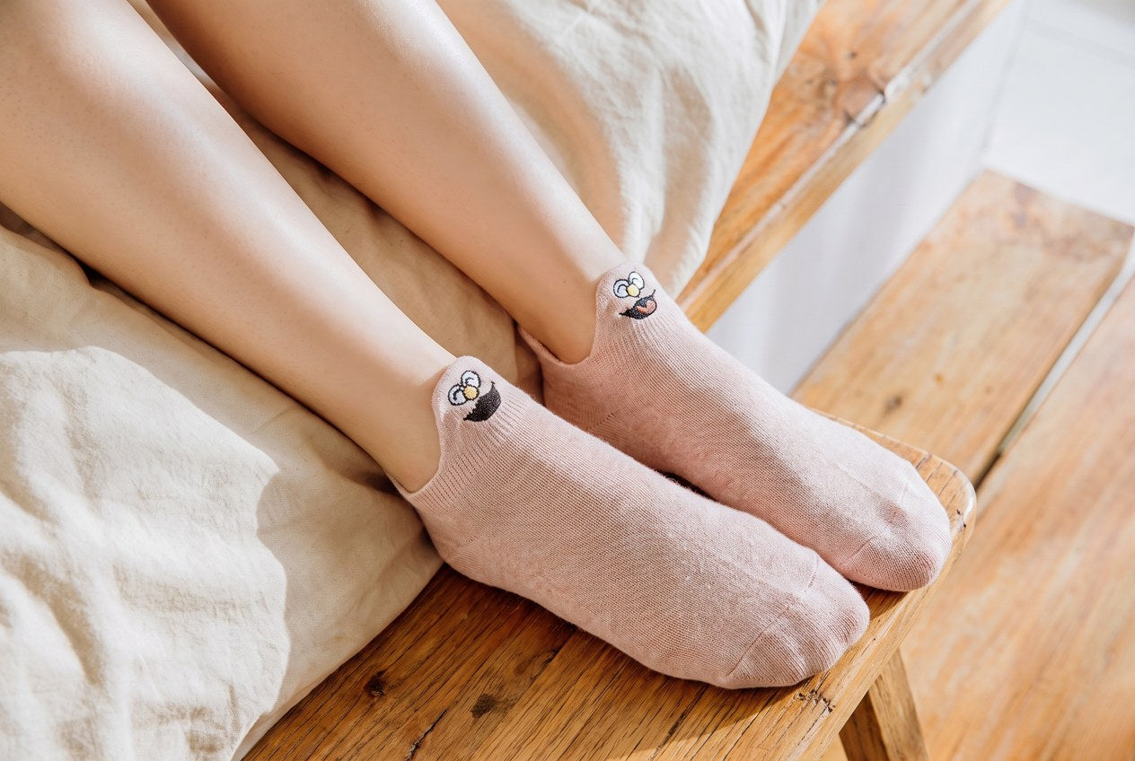Pink TASSA socks with little faces on the heel tabs