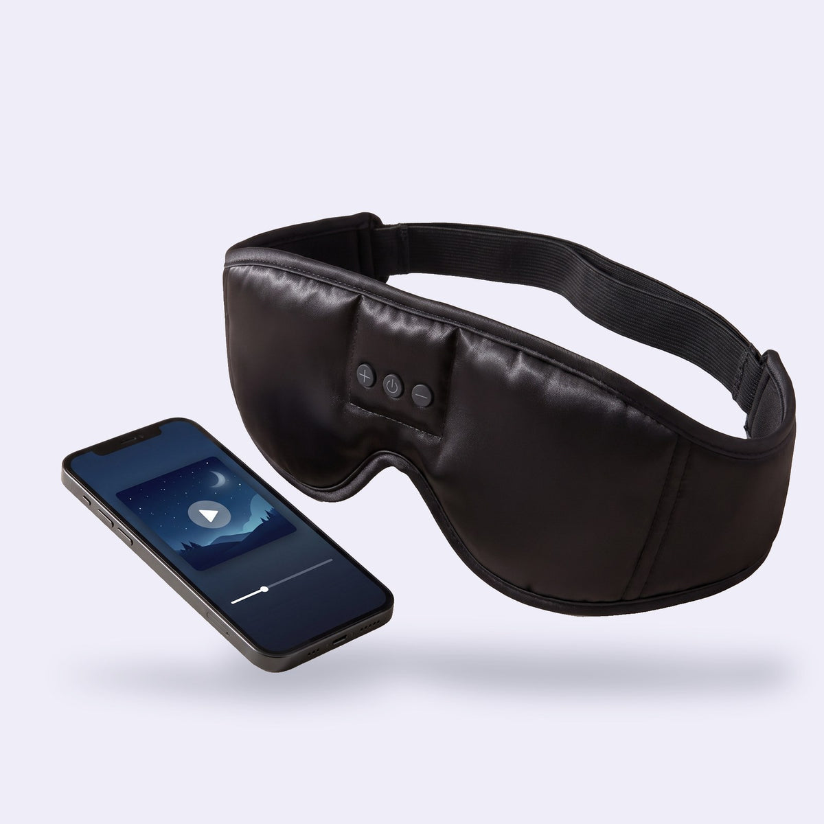 Hushband sleep headphones in black satin next to a phone playing sleep sounds