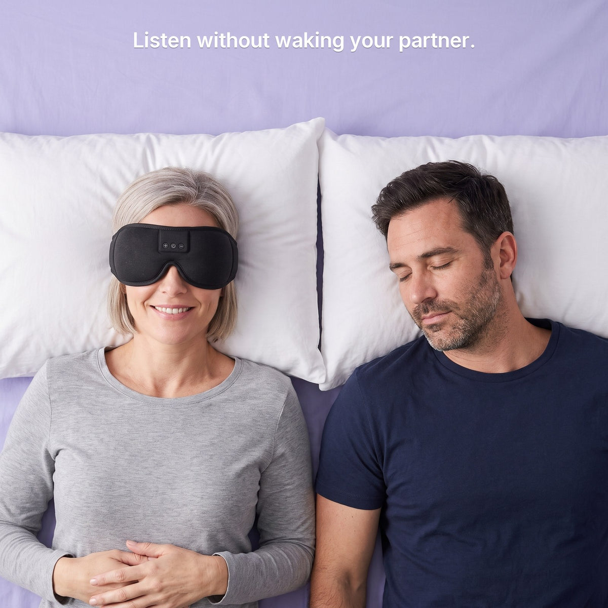A woman listening in a Hushband sleep mask while her partner sleeps beside her