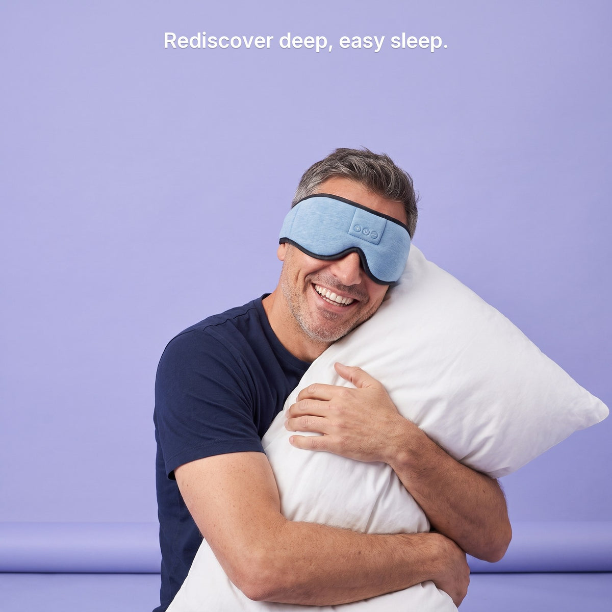 A smiling man hugging a pillow in the sky blue Hushband