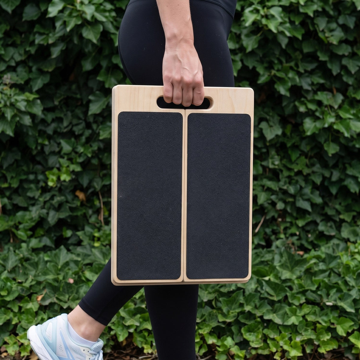 Carrying the folded Incline Stretch Board by its handle
