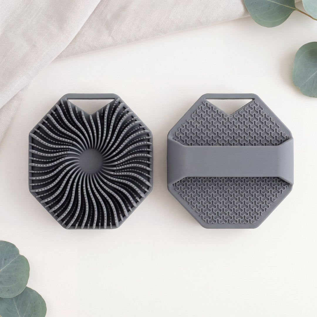 Both sides of the SKURA scrubber: the fin side and the strap side