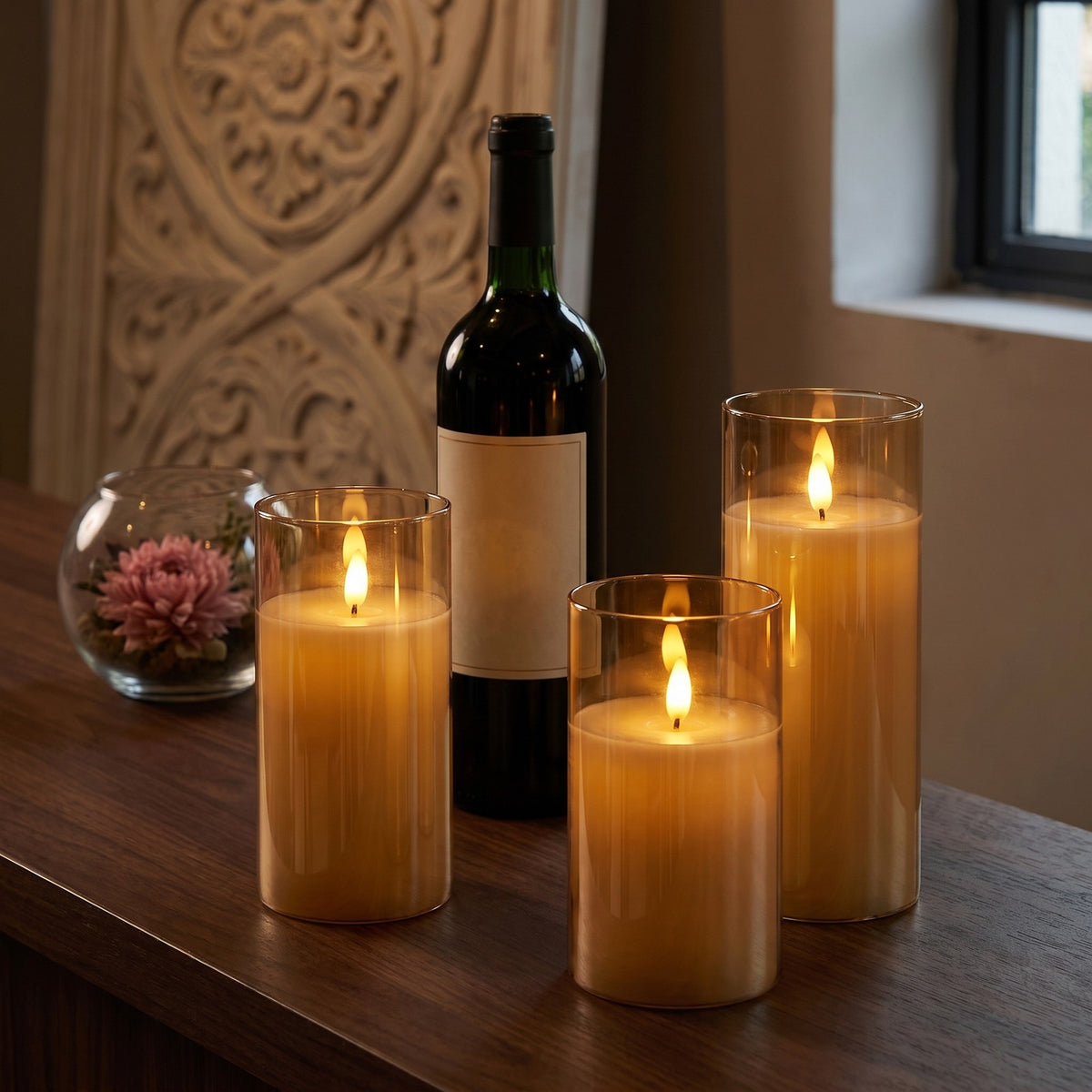 Amber VEKE candles glowing on a dark counter beside a wine bottle